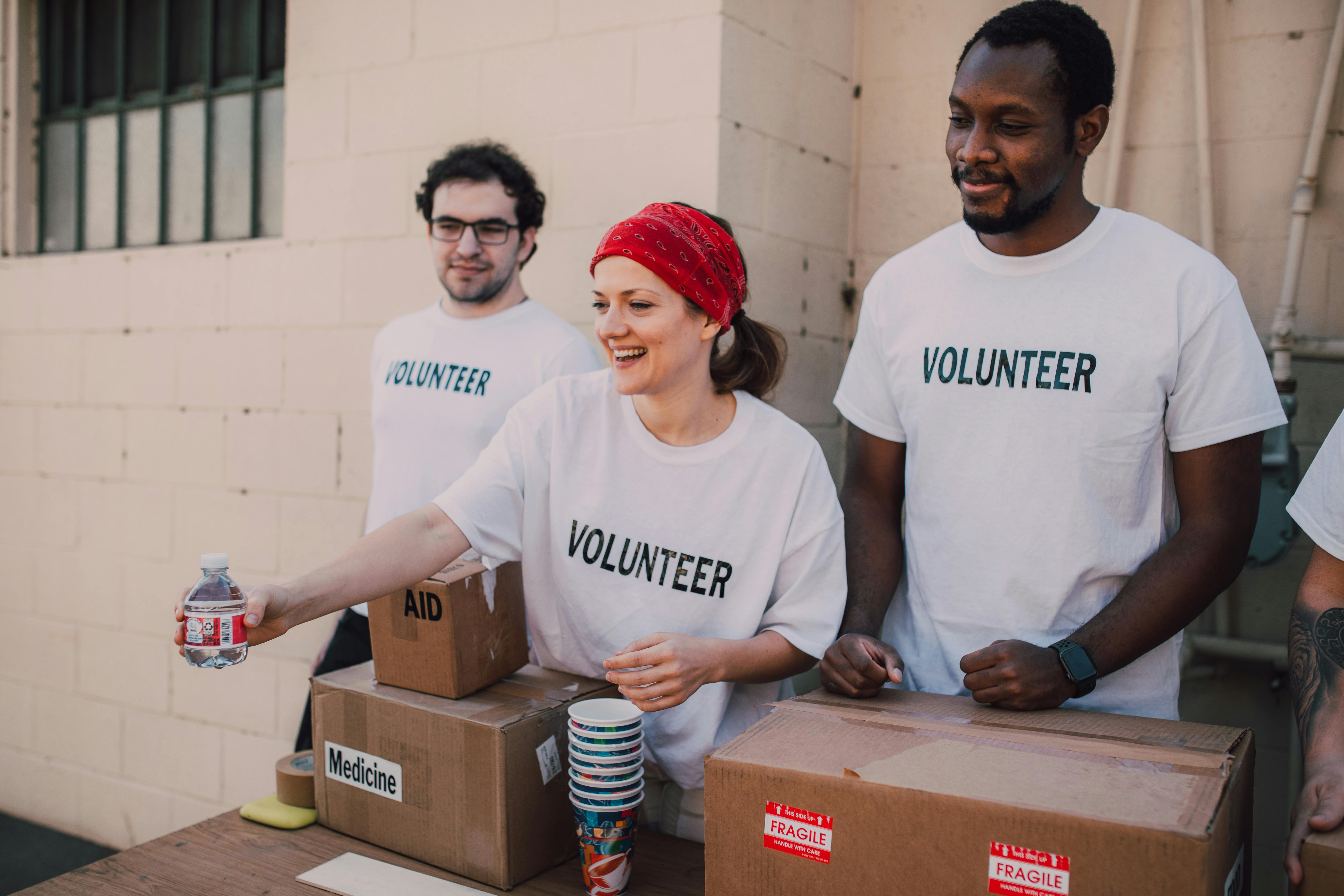 Group of volunteers giving water and medicine to the needy